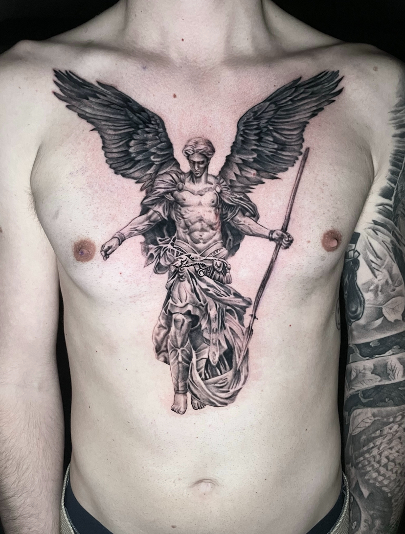 Black and grey-tatuering av ärkeängel med spjut över bröstet
